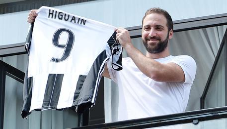 L'agentino mostra la maglia della Juve Argentinian striker Gonzalo Higuain, new player of Juventus, after arriving to the head office of his soccer team, shows the skirt number 9, Turin, 27 July 2016. ANSA/ ALESSANDRO DI MARCO