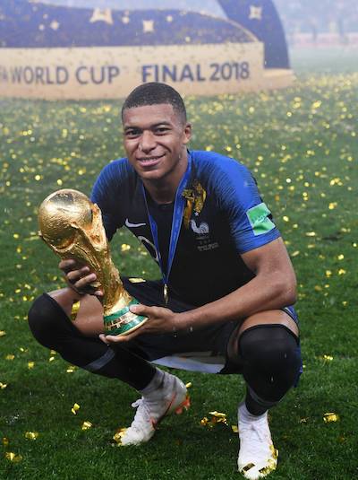 Kylian Mbappé avec le trophée de la Coupe du Monde de football lors de la victoire des Bleus contre la Croatie en 2018.